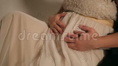一对夫妇穿着婚纱`腹部特写。